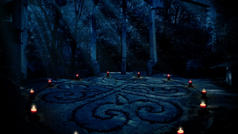 Circle of lit candles in a dark forest