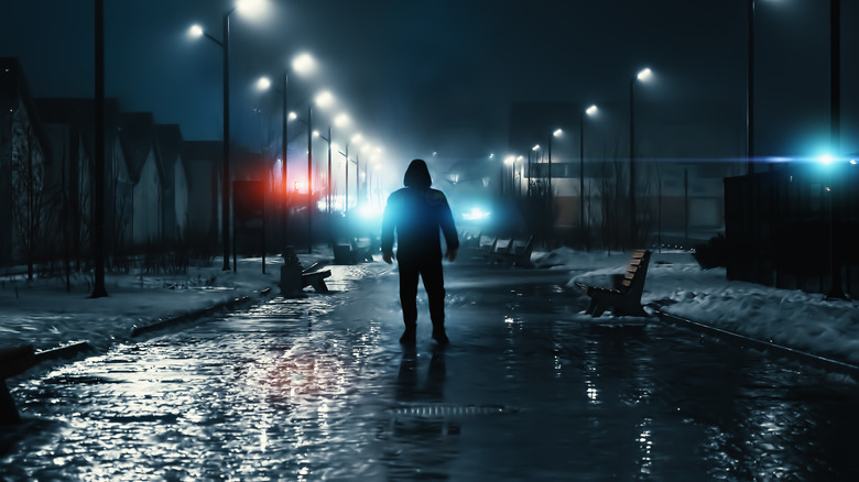 hooded figure night suburban street