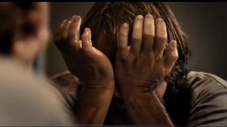 man with hands over face