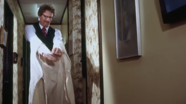 man taking off white apron
