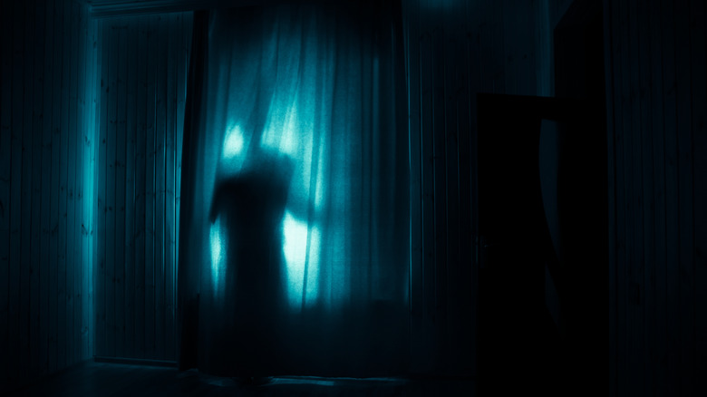 Creepy shadow behind a curtain