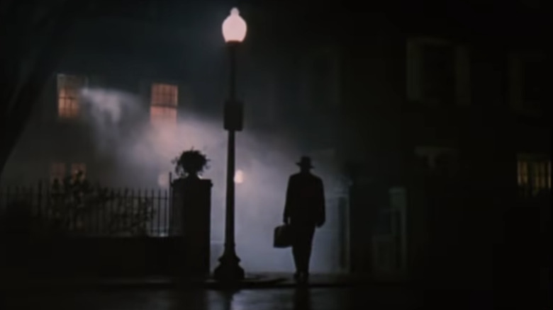 man walking in fog up to house