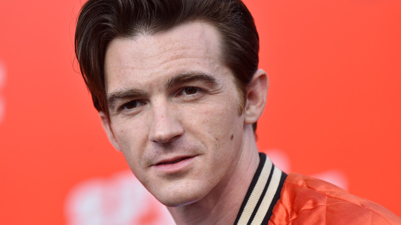Drake Bell in front of an orange background