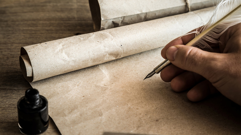 Quill pen over a blank scroll