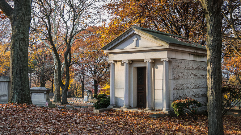 Simple mausoleum in autumn graveyard