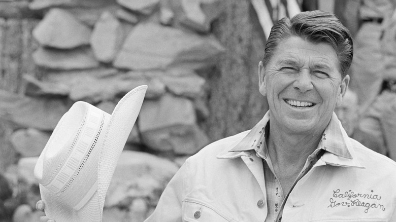 Ronald Reagan with hat aloft in outdoor gear