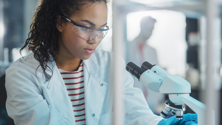 Researcher looking at microscope