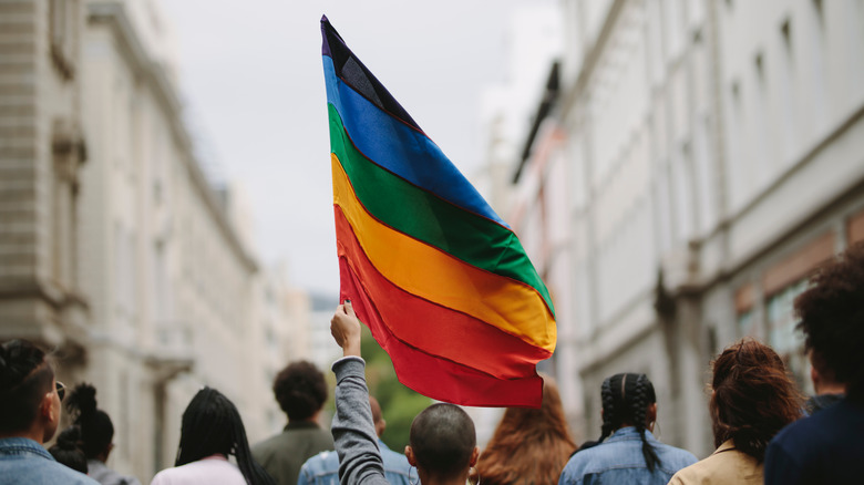 group holding rainbow pride flag