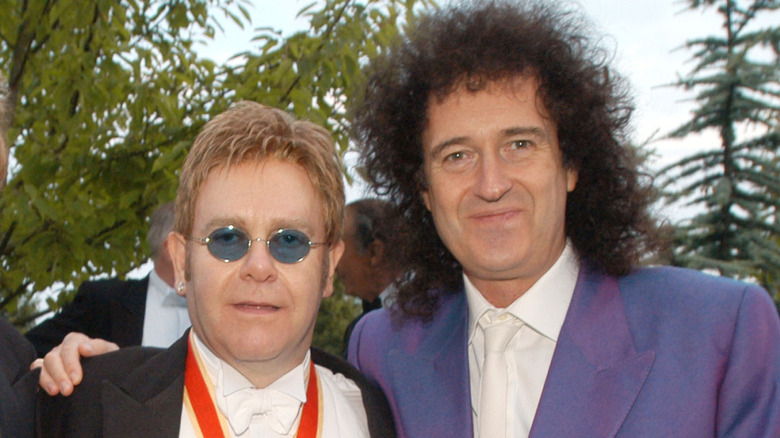 Brian May of Queen embracing Elton John