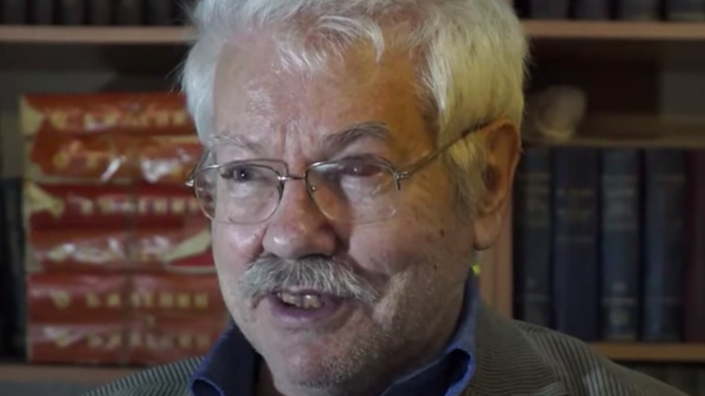 Nikolai Andrushchenko glasses smiling books in background