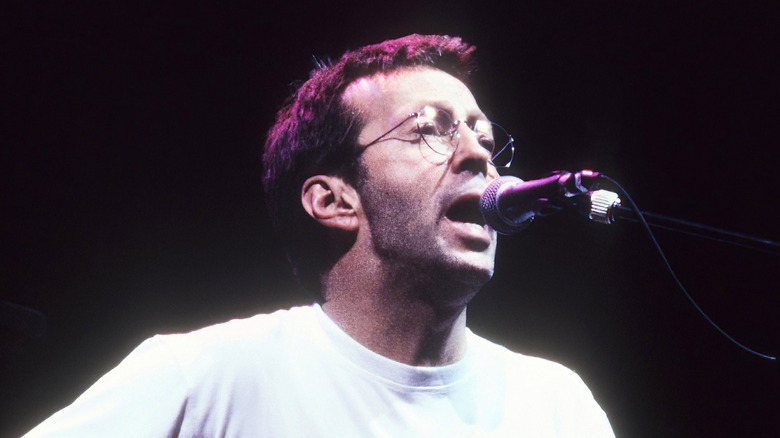 Eric Clapton singing and playing guitar on stage in the 1990s