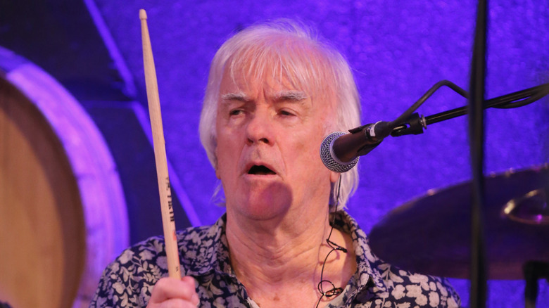 Jim McCarty singing while playing drums