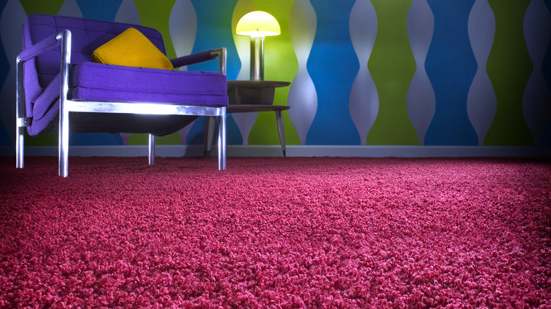 chair and table with lit lamp on shag carpet