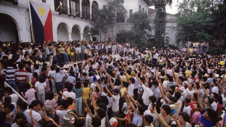 A crowd of happy opposition supporters outside the president's house in the Philippines