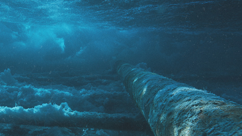 A pipe stretches across the ocean floor