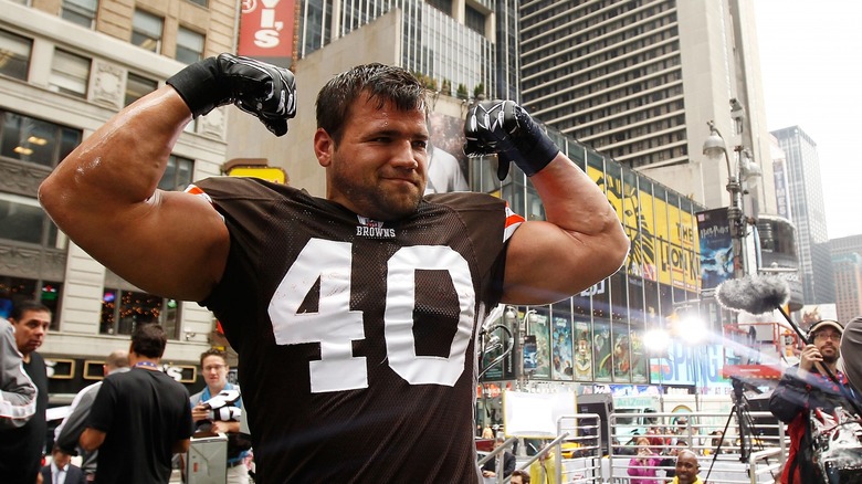 Peyton Hillis flexing arms outside