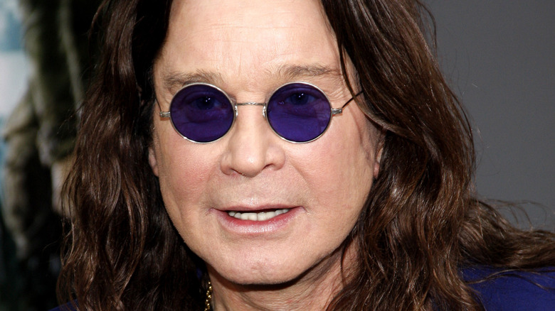 Ozzy Osbourne wearing round purple glasses at an event