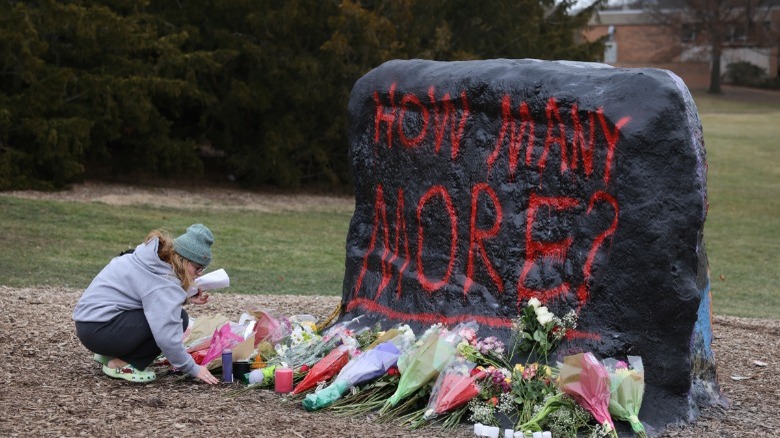 woman, flowers, words painted on rock