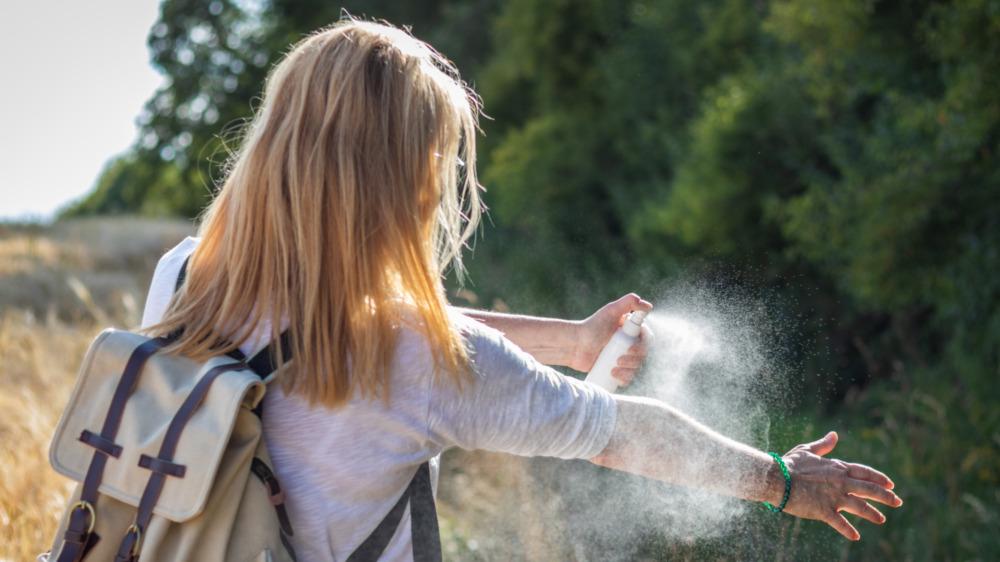 Woman applies insect repellant