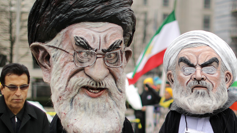An American protester wears a Khamenei mask