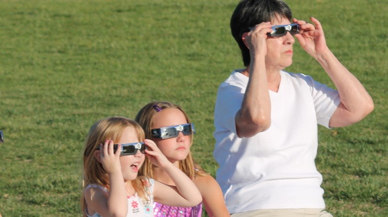 People looking at eclipse through filtered glasses
