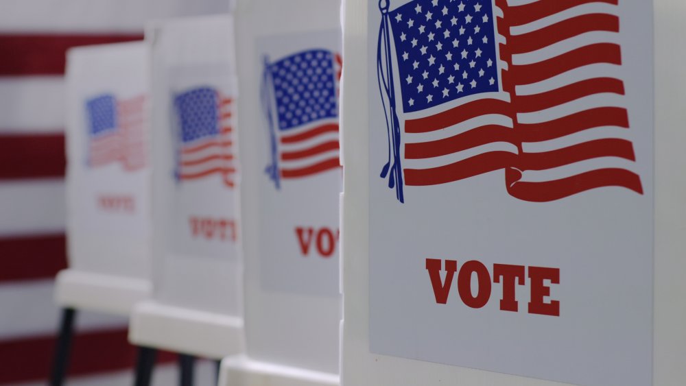 A row of voting machines adorned with American flags