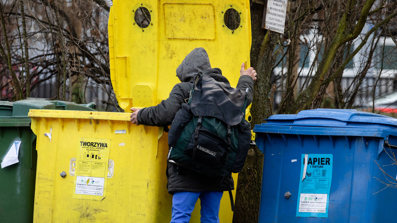 person digging in trash
