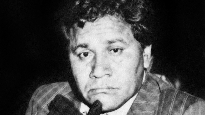 Oscar Zeta Acosta touching gloved hand to face