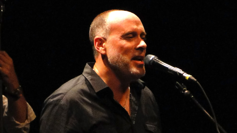 marc cohn singing into a microphone on stage in the 90s
