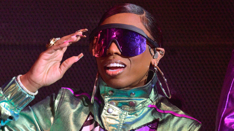 missy elliott wearing purple shades and green jumpsuit onstage