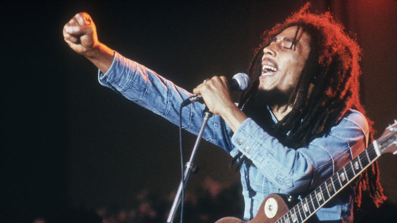 Bob Marley performing on stage with fist in the air