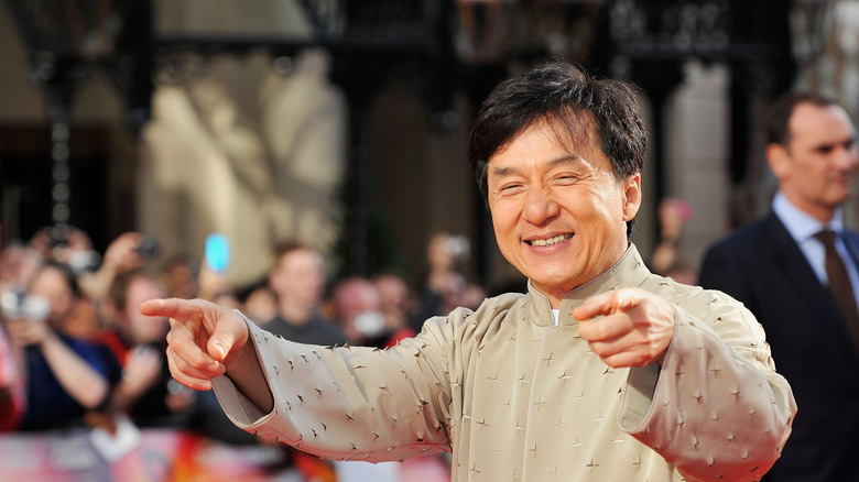 Jackie Chan pointing fingers and smiling at an event