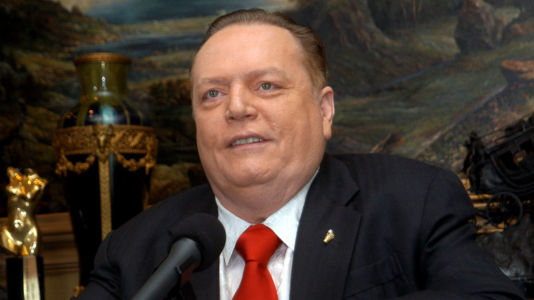 Larry Flynt sitting behind a desk and smiling