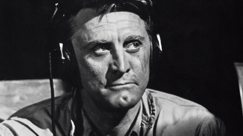 Kirk Douglas flying a plane in a movie and looking away