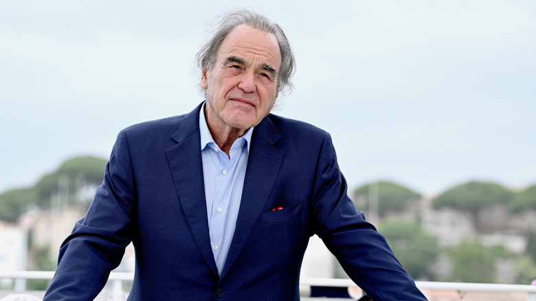 Oliver Stone in a suit outside at Cannes