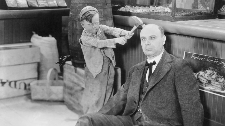 A young Bobby "Wheezer" Hutchins hitting a man on the head in a film