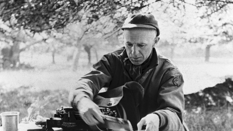 Ernie Pyle working at a small desk outside
