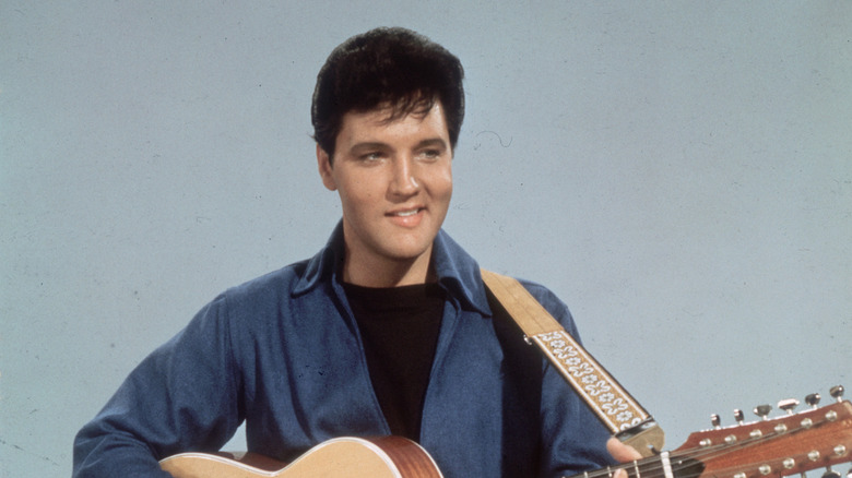 Elvis Presley smiling with guitar