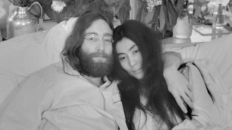 Yoko Ono and John Lennon in bed hugging