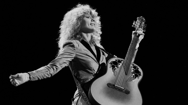 Black and white photo of Nancy Wilson playing guitar in concert