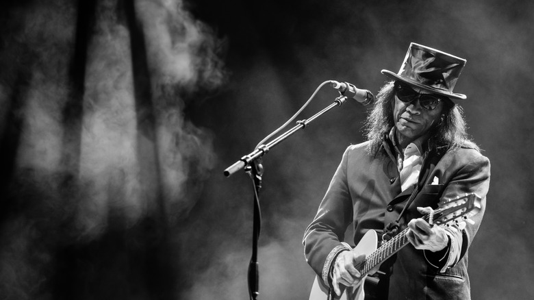 Rodríguez performs with guitar and top hat in the U.K.