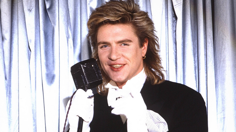 Simon Le Bon squinting in front of silver curtain