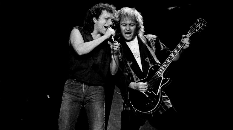 A black and white photo of Lou Gramm and Mick Jones of Foreigner performing together in 1994.