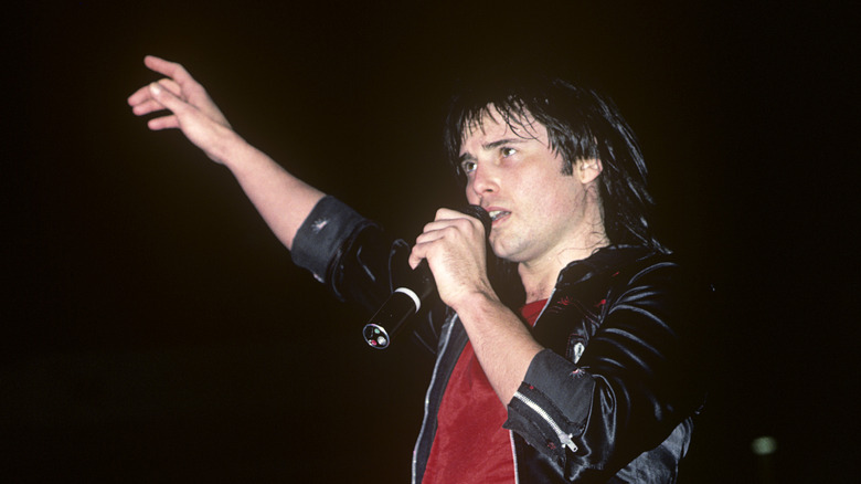 Jimi Jamison gesturing one hand mic onstage