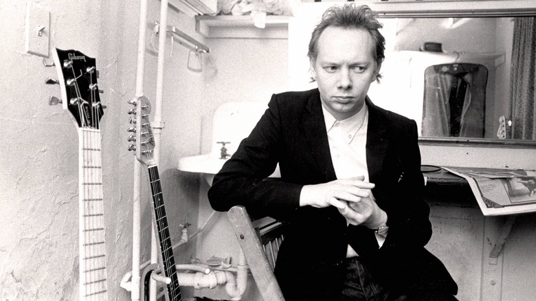 Joe Jackson poses for portrait alongside guitars