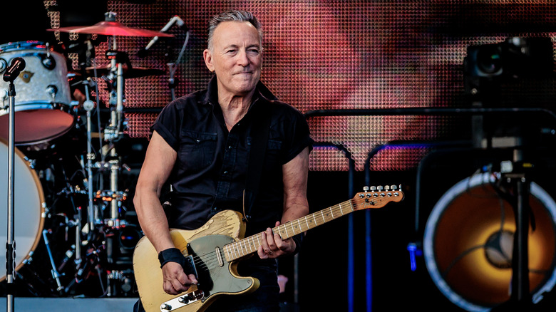 Bruce Springsteen smiling while playing guitar