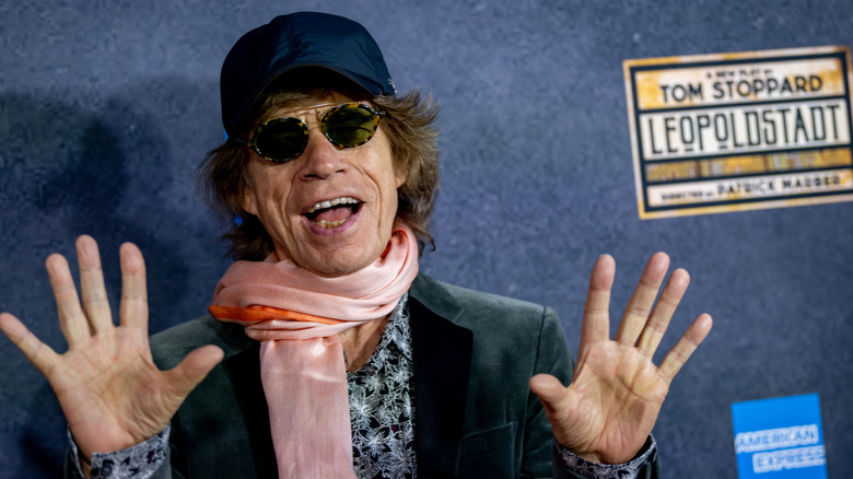 Mick Jagger wearing a baseball cap and sunglasses