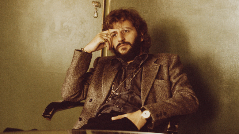 Bearded Ringo Starr seated at a table