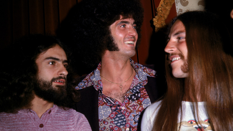 Grand Funk members smiling at each other