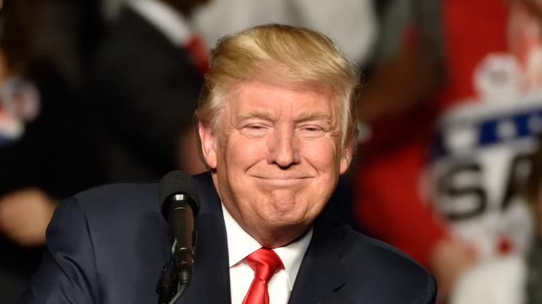 Donald Trump smiling at a lectern